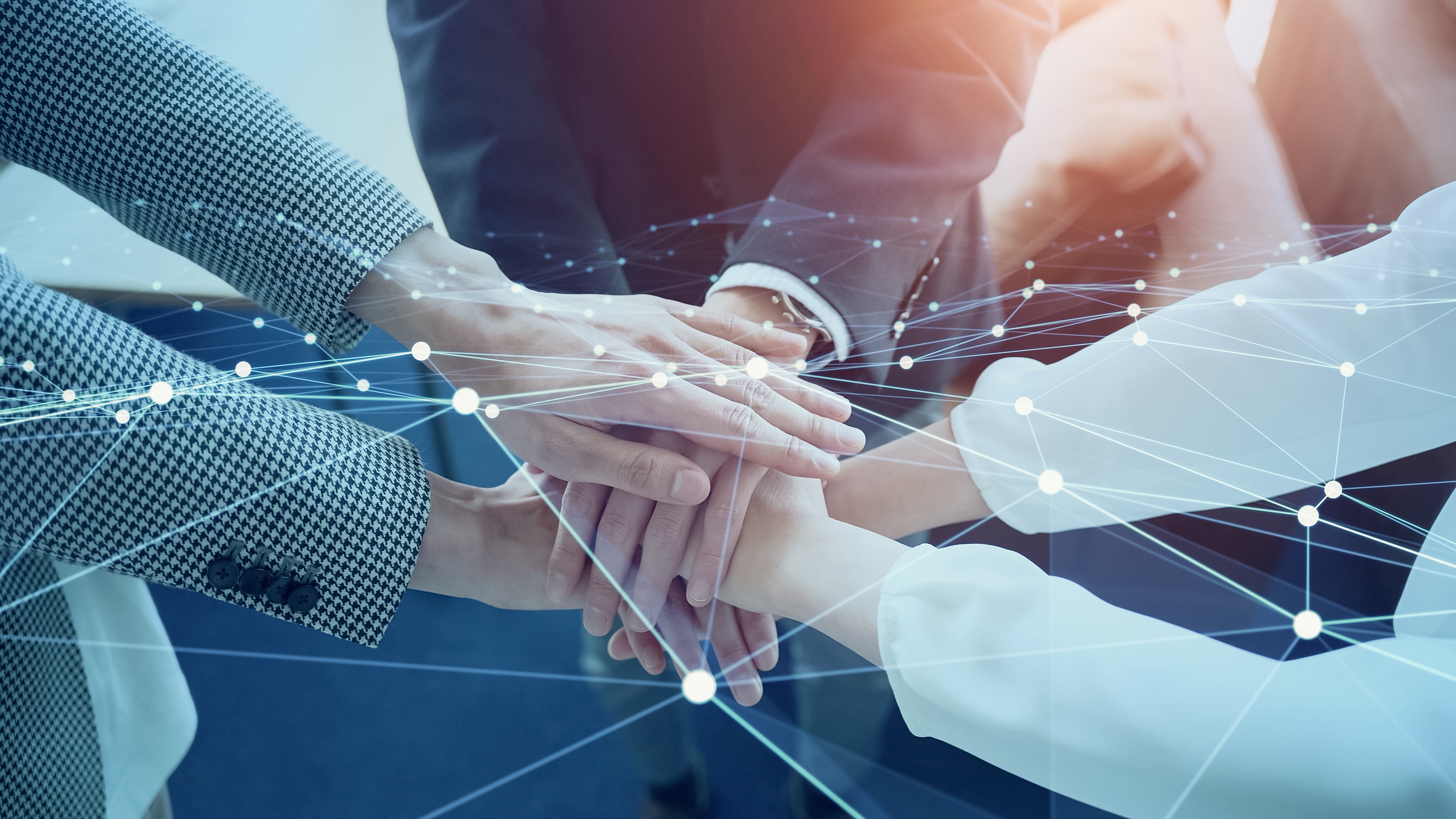 Mehrere Hände übereinander als Team-Geste